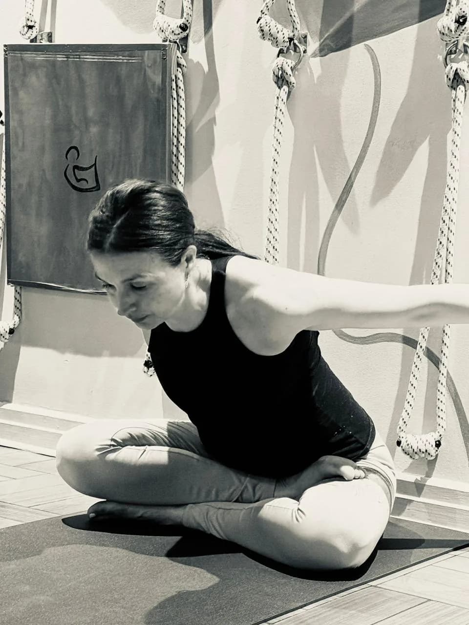 Andrea Berríos practicando una torsión sentada sobre el mat